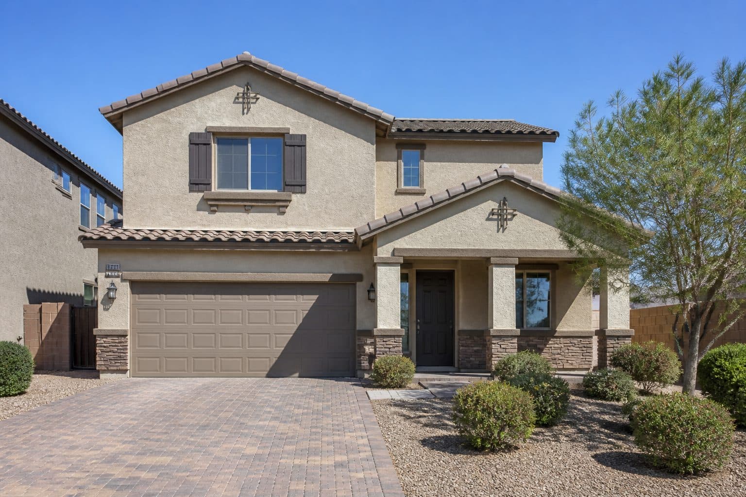 Two-story beige stucco home with attached garage in Manzano Peak Las Vegas