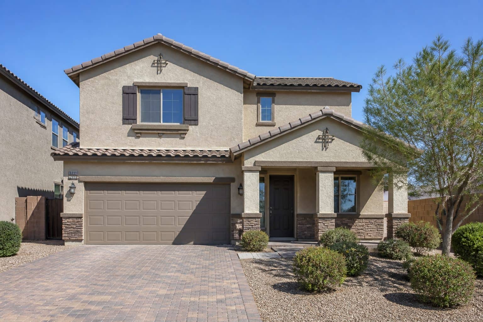 Two-story beige stucco home with attached garage in Manzano Peak Las Vegas